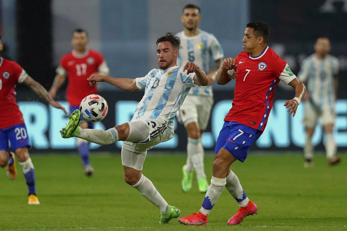Nicolás Tagliafico anticipa al chileno Alexis Sánchez durante el partido entre la Argentina y Chile, que se disputa en el estadio Madre de Ciudades, de Santiago del Estero.