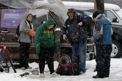 Un grupo de personas que comparten una camioneta se reunieron en una calle del barrio SODO de Seattle para protegerese del frío