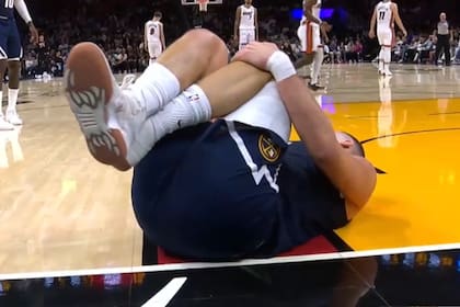 Nikola Jokic, tendido en el piso, luego se ser pisado por un compañero