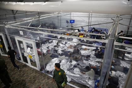 Niños acostados dentro de una celda en el principal centro de detención para niños no acompañados en Rio Grande Valley