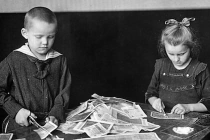 Niños alemanes destruyen con tijeras los billetes que ya no tenían valor