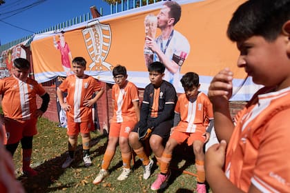 Niños del club de fútbol Grandoli, donde Messi jugó de niño, escuchan a su técnico previo a un partido en Rosario, Argentina, el sábado 2 de mayo de 2026. (AP Foto/Rodrigo Abd)