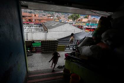 Niños indígenas embera juegan donde miles de emberas desplazados por años de conflicto armado interno y condiciones de vida precarias en la región central occidental de Colombia se han refugiado en Bogotá, el jueves 28 de noviembre de 2024. (AP Foto/Fernando Vergara)
