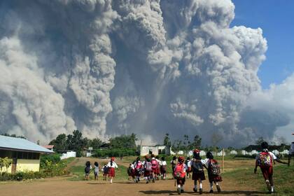 Niños observan la erupción del Monte Sinabung, en Kari, al norte de la isla de Sumatra, en Indonesia