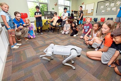 Niños saludan a un perro robótico Unitree Go2, operado por Aaron Fisher, de Aidex East Educational Systems, el jueves 10 de julio de 2025, durante el Día del Sueño STEAM de los Boys & Girls Clubs del Gran Suroeste de Michigan, celebrado en Benton Harbor, Michigan