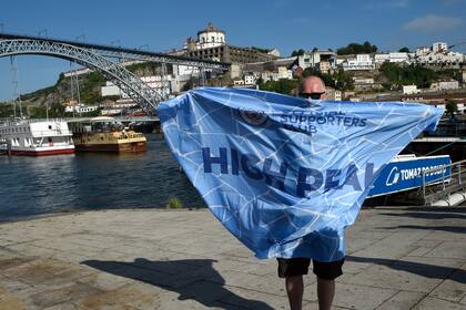 No es un barbijo enorme, sino una bandera de hincha de fútbol: la pandemia parece un mal recuerdo para este simpatizante de Manchester City, que disfruta el sol, el clima templado y la zona de Ribera en Porto, más la inminencia del desenlace de la Champions.