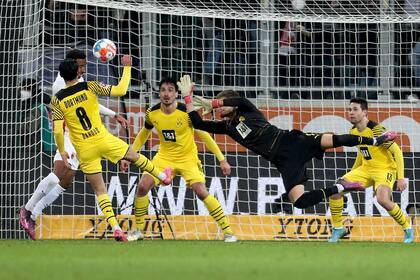 Noah Saranren Bazee (segundo a la izquierda) anota el gol para Augsburgo en el empate 1-1 contra Borussia Dortmund por la Bundesliga, el domingo 27 de febrero de 2022. (AP Foto/Alexandra Beier)