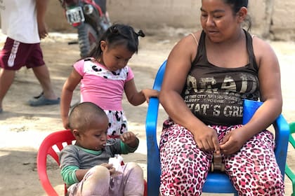 Noé Bravo come el superalimento donado por Unicef a cucharadas, ante la mirada atenta de su mamá y su hermana