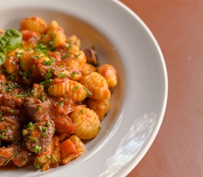 Ñoquis con ragú de cordero, de cocción lenta durante cuatro horas, además de opciones con boloñesa, tuco o salsa de hongos en Raíces