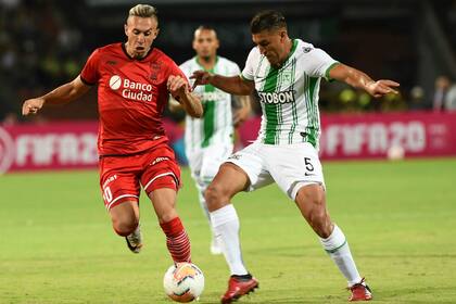 Norberto Briascos (Huracán) disputa la pelota con el argentino Diego Braghieri (Atlético Nacional).