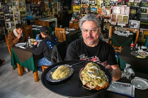 Norberto Meza con la milanesa Don Ignacio, que lleva salsa, mozzarella, jamón, cebolla, orégano y dos huevos fritos