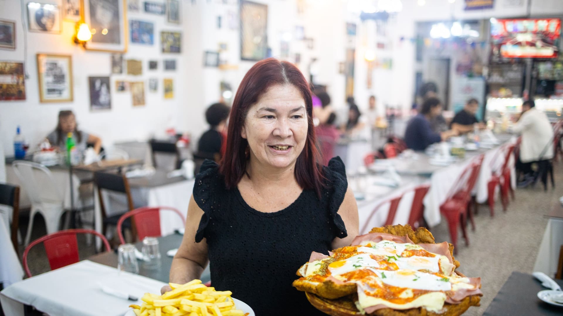 Norma Orrego sirve la milanesa Supertábano, la especialidad del bodegón del club El Tábano, un ícono del barrio de Saavedra