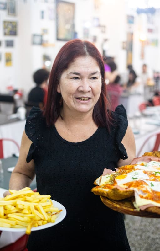 Norma Orrego sirve la milanesa Supertábano, la especialidad del bodegón del club El Tábano, un ícono del barrio de Saavedra
