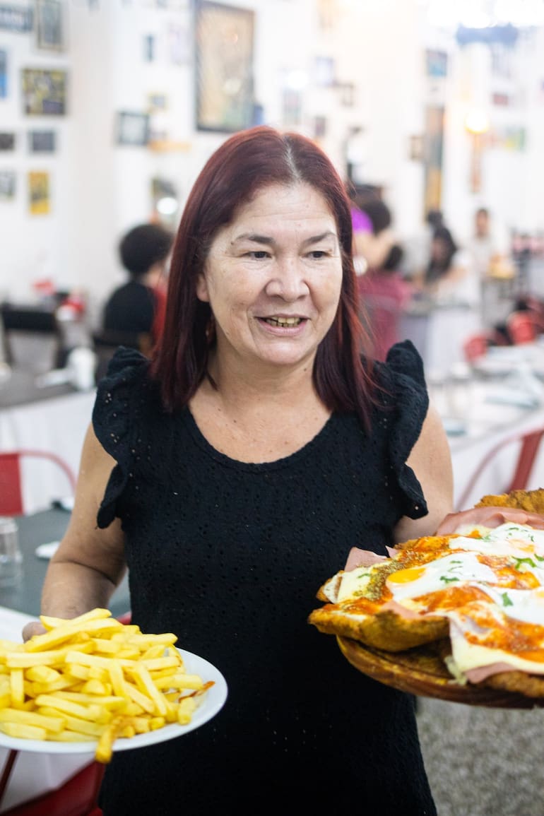 Norma Orrego sirve la milanesa Supertábano, la especialidad del bodegón del club El Tábano, un ícono del barrio de Saavedra