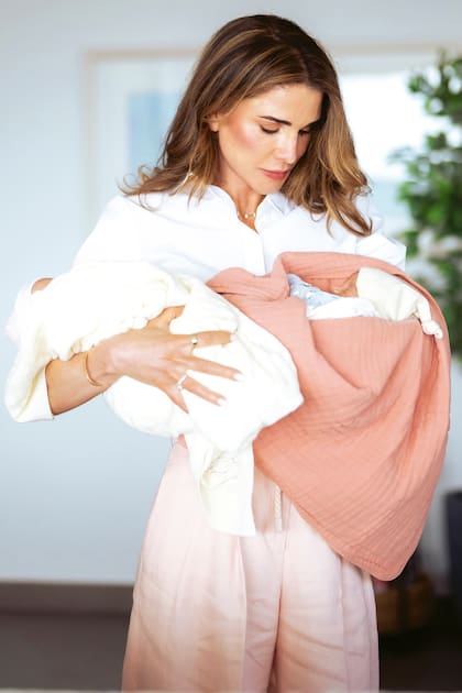 La soberana hachemita, con una camisa blanca y un pantalón de lino rosa, a tono con las mantitas de las gemelas Rania y Talia. Para los jordanos, los colores son muy importantes: de hecho, para cada posado oficial los royals tratan que sus outfits coincidan