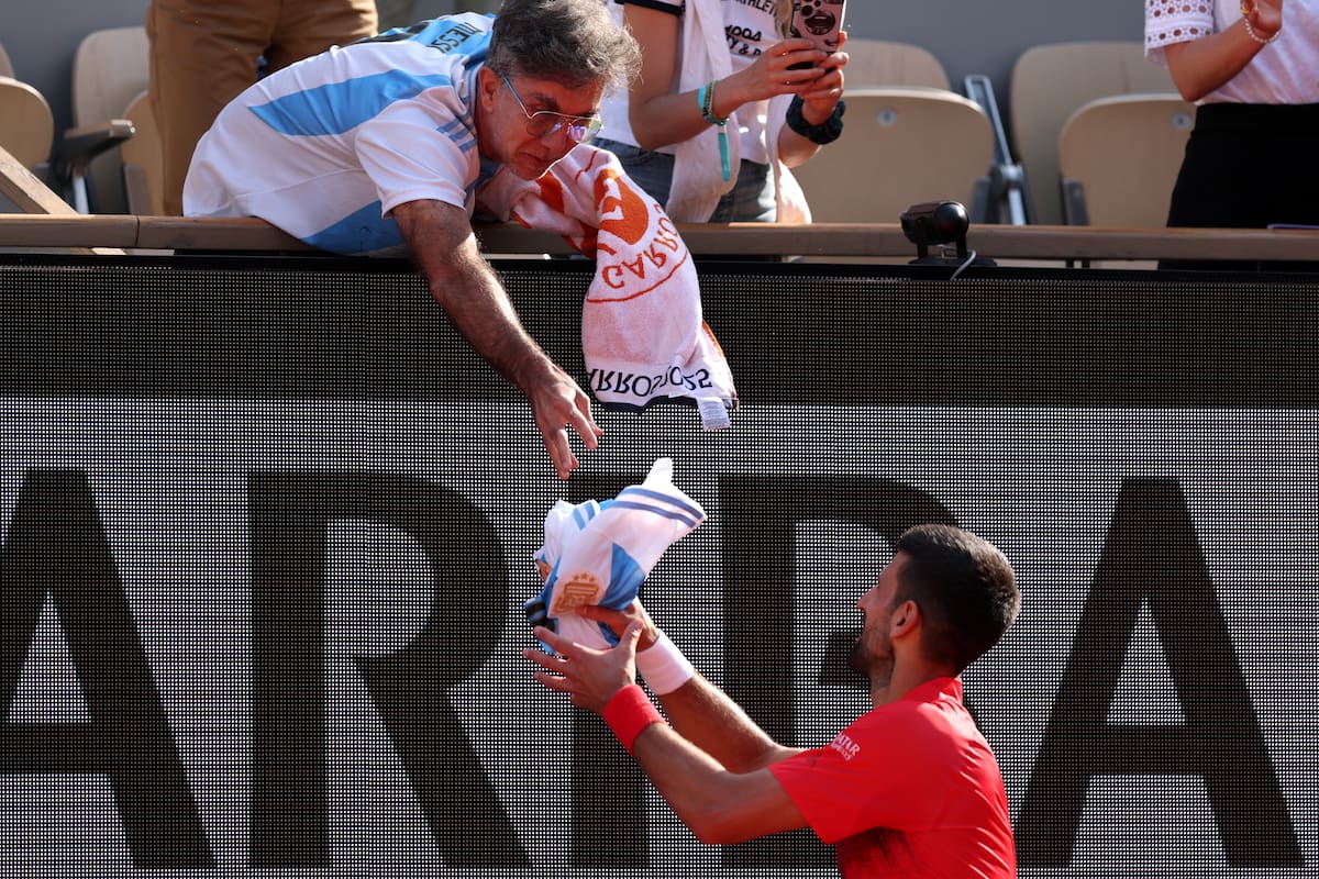 Novak Djokovic acaba de vencer a Cameron Norrie en el court Philippe-Chatrier y avanzar a los cuartos de final de Roland Garros; recibe de Gustavo Moledo una camiseta argentina