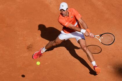 Novak Djokovic devuelve ante Aslan Karatsev en el Abierto de Italia, en Roma, el martes 10 de mayo de 2022. (AP Foto/Andrew Medichini)