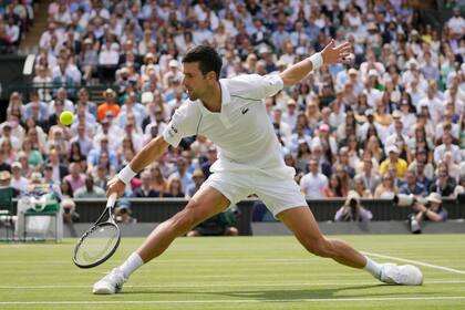 Novak Djokovic devuelve ante Matteo Berrettini en la final de Wimbledon, el domingo 11 de julio de 2021, en Londres. (AP Foto/Kirsty Wigglesworth)