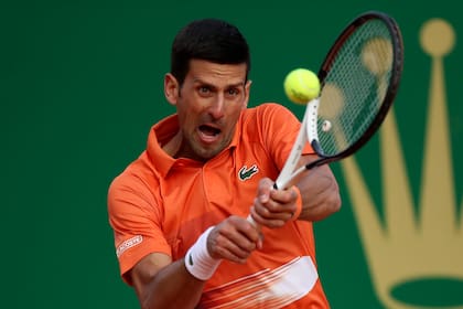 Novak Djokovic devuelve durante su partido contra Alejandro Davidovich Fokina en el Masters de Montecarlo, el martes 12 de abril de 2022, en Mónaco. (AP Foto/Daniel Cole)