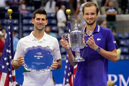 Novak Djokovic posa con el plato como finalista; Daniil Medvedev, con la copa de campeón, luego de una gran final en el US Open
