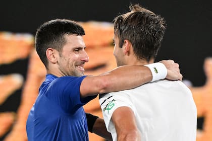 Novak Djokovic sonríe con Tomás Etcheverry en el saludo final tras el encuentro que sostuvieron en la tercera ronda del Australian Open
