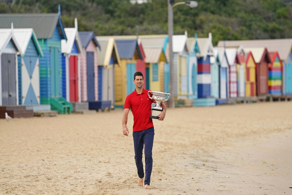 Novak DJOKOVIC sostiene la Norman Brookes Challenge Cup mientras celebra la victoria después de su final masculina individual en la sesión de fotos del trofeo en Brighton Beach el día después de ganar el Abierto de Australia el lunes 22 de febrero de 2021.