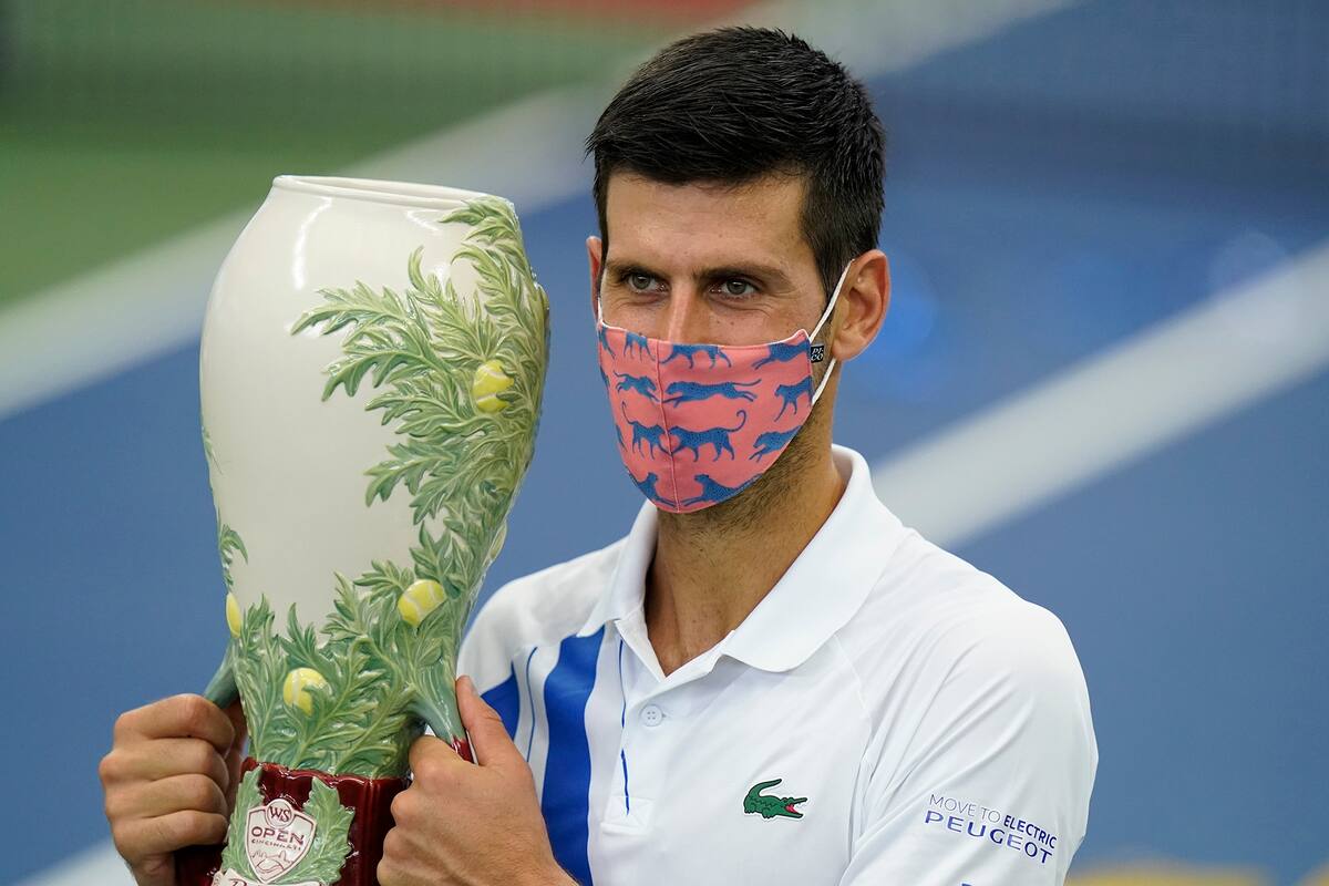 Novak Djokovic sostiene su trofeo después de ganar su partido con Milos Raonic, de Canadá, en el torneo de tenis Western Southern Open