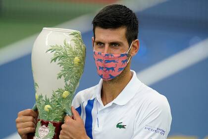 Novak Djokovic sostiene su trofeo después de ganar su partido con Milos Raonic, de Canadá, en el torneo de tenis Western Southern Open