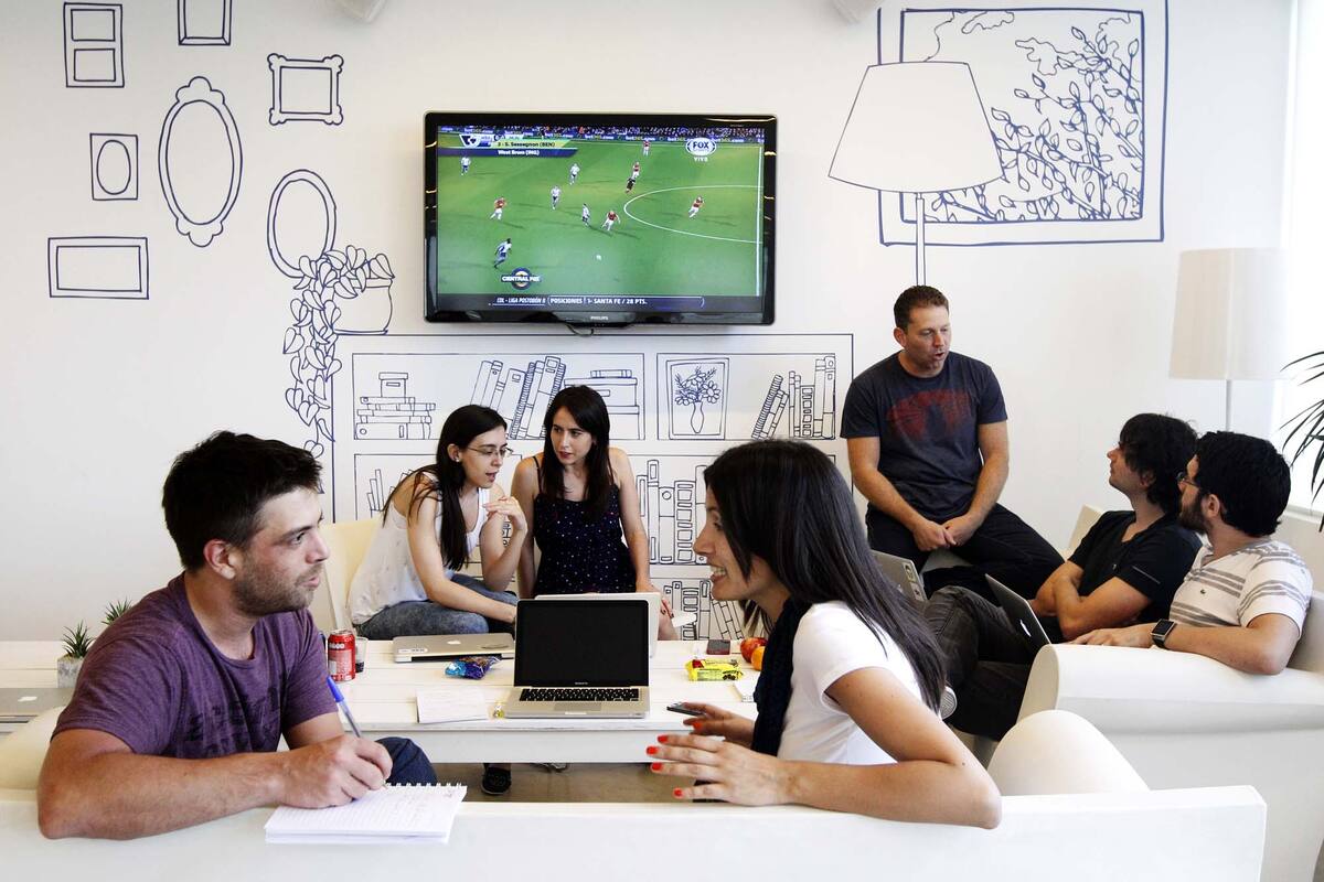 Nuevas maneras de trabajar. Un grupo de empleados de Mercado Libre establece objetivos en una habitual reunion de trabajo en un living de la oficina.