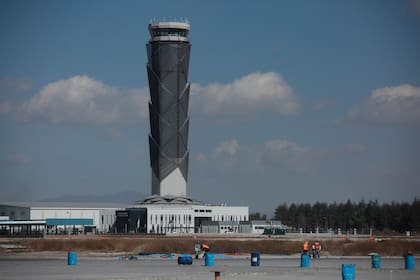 Con el telón de fondo de la torre de control de tráfico aéreo, los empleados trabajan en el nuevo Aeropuerto Internacional Felipe Ángeles, en las afueras de la Ciudad de México, el 31 de enero de 2022.