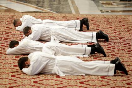 Nuevos sacerdotes yacen boca abajo durante su ceremonia de ordenación oficiada por el papa Francisco al interior de la Basílica de San Pedro en el Vaticano, el domingo 25 de abril de 2021. (AP Foto/Andrew Medichini)