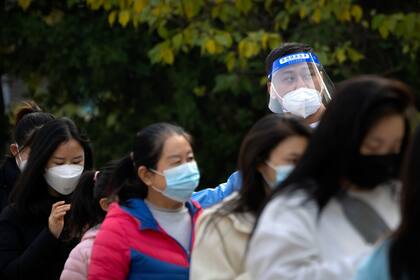 Numerosas mujeres hacen fila para hacerse pruebas de COVID-19 en un lugar especial en Beijing, el jueves 10 de noviembre de 2022. (AP Foto/Mark Schiefelbein)