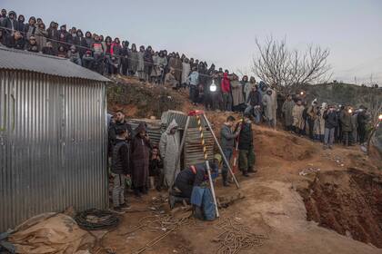 Numerosos lugareños observan la excavación a cargo de autoridades locales y de protección civil en una colina en su intento para rescatar a un niño de 5 años que cayó en un pozo cerca de la localidad de Bab Berred, cerca e Chefchaouen, Marruecos, el jueves 3 de febrero de 2022. (AP Foto)