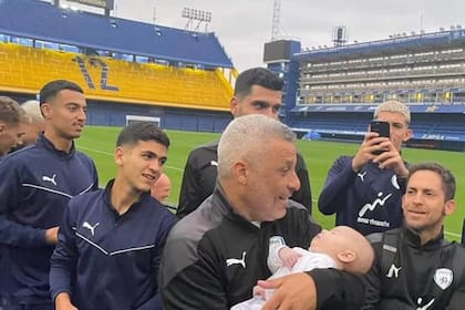 Ofer Haim, entrenador de la selección israelí Sub 20, con un bebé en brazos y algunos de sus jugadores durante una visita a la Bombonera