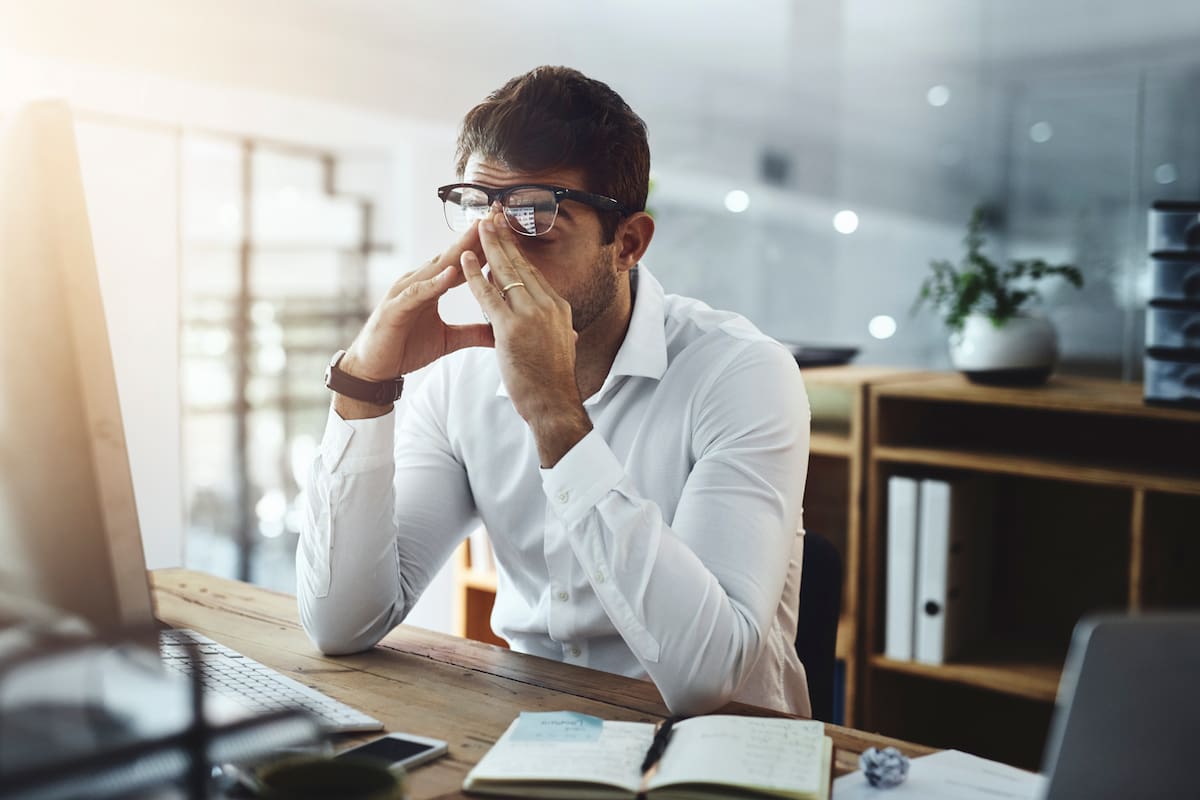 Office, stress and business man on computer for deadline on web design, project and research. Corporate, company and exhausted, fatigue and overworked person on pc for website, email and burnout