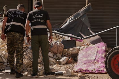 Oficiales de inteligencia libaneses observan un misil sin explotar, en el centro, en el lugar donde un ataque aéreo israelí impactó un edificio en Dahiyeh
