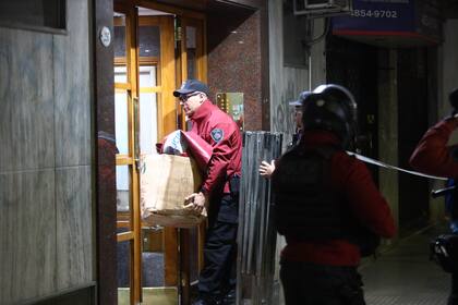 Oficiales de la Policía de la Ciudad ingresan al edificio donde encontraron muertos a una pareja y a sus dos hijos muertos