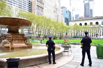 Oficiales de la policía de Nueva York custodian los parques de la ciudad para asegurar el cumplimiento del distanciamiento social
