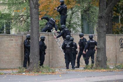 Oficiales de policía cruzan una pared en la escena del crimen en Halle