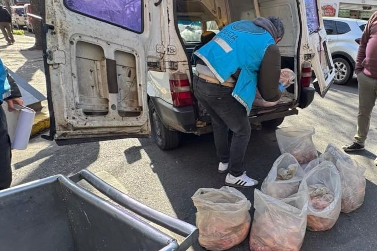 Oficiales descargan bolsas con achuras y embutidos desde una camioneta blanca interceptada durante el operativo