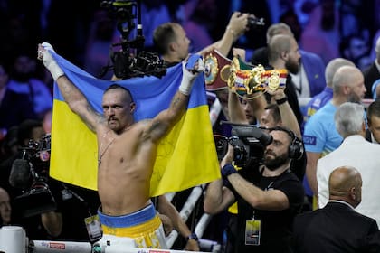 Oleksandr Usyk festeja con la bandera ucraniana tras vencer por puntos a Anthony Joshua en Arabia Saudita, por la corona de los pesados de tres entidades mundiales.