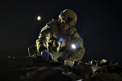 Oleksii Yukov examina el cuerpo de un soldado ruso que recogió en el frente en la región de Slaviansk, Ucrania, el 24 de octubre de 2023