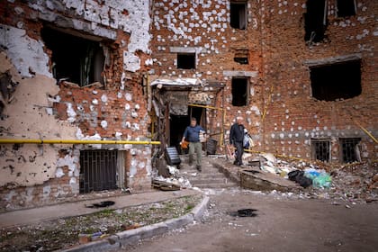 Oleksiy Onoschenko, de 42 años, rescata libros de su casa destruida durante la ocupación rusa en Irpín, a las afueras de Kiev, Ucrania, el sábado 30 de abril de 2022. (AP Foto/Emilio Morenatti)