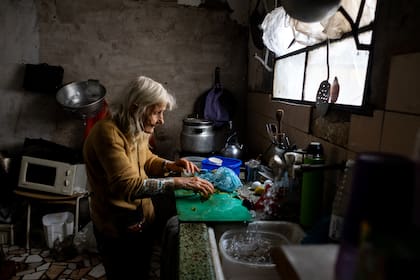 Olga, una jubilada, cocina en su casa con verduras que recogió de la calle; San Martín, mayo de 2025