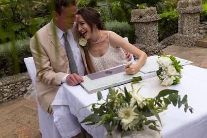 Olivia Windham Stewart, que es británica y su nuevo esposo, Michael, firman el registro de matrimonio durante su ceremonia en el Jardín Botánico de Gibraltar el 5 de septiembre de 2020