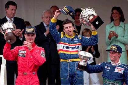 Olivier Panis celebra en el podio de Montecarlo flanqueado por el escocés David Coulthard (McLaren) y el inglés Johnny Herbert (Sauber); detrás, observan el príncipe Rainiero y la princesa Carolina.