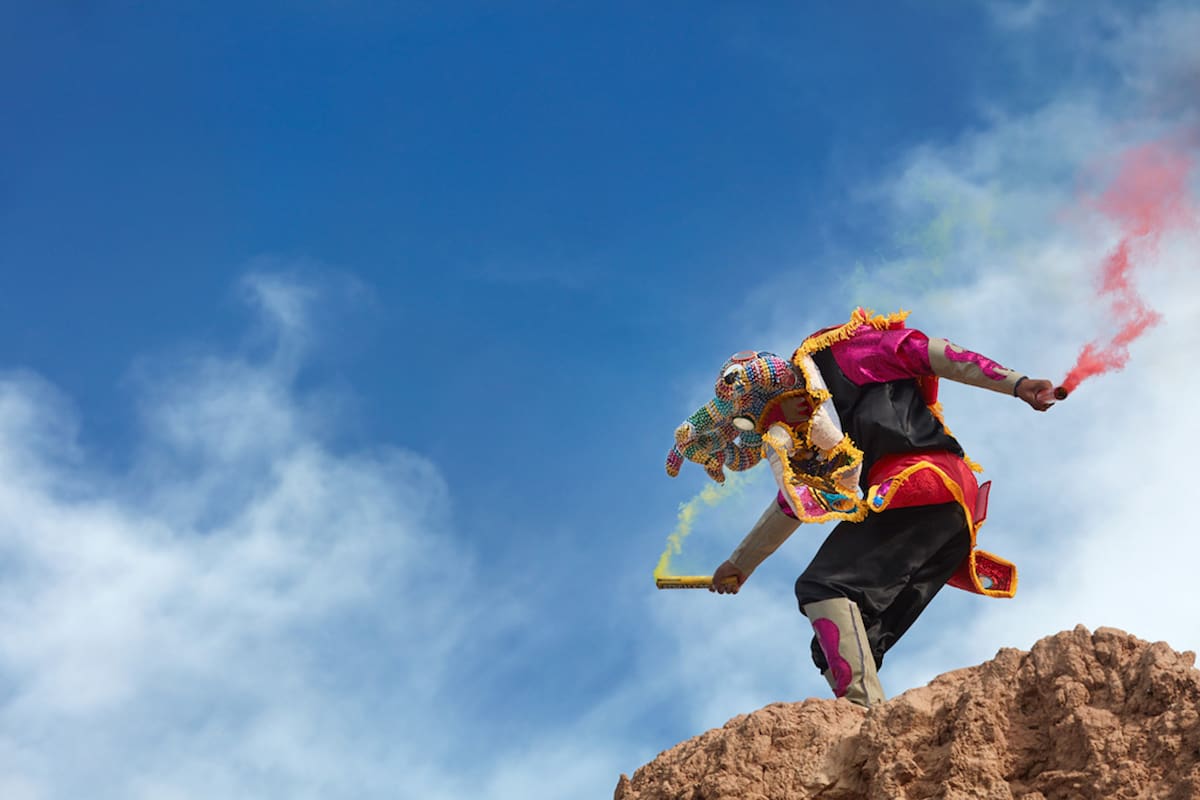 One of the "Devil's" masks of the Uquía Carnival with colorful bengala's during the "Descents of the Devil's", Jujuy province, Argentina.