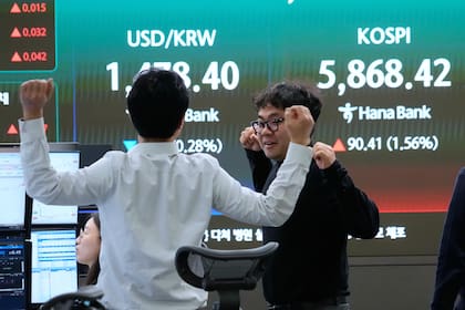 Operadores trabajan frente a una pantalla que muestra al Indicador Compuesto de Precios de Corea y la tasa cambiaria en la sede del Banco Hana, el viernes 10 de abril de 2026, en Seúl, Corea del Sur. (AP Foto/Ahn Young-joon)
