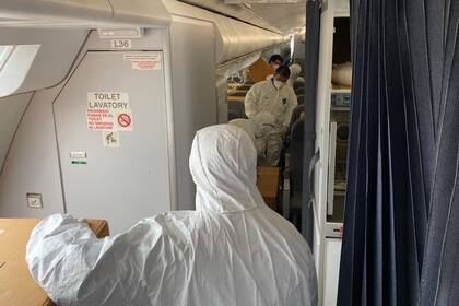 Operarios del aeropuerto de China, distribuyen la carga en la cabina
