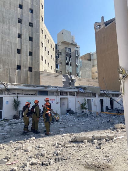 Operarios entre cascotes y otros restos tras la caída del misil iraní